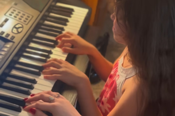 Piano teacher guiding child through musical expression and proper hand positioning in Washington DC